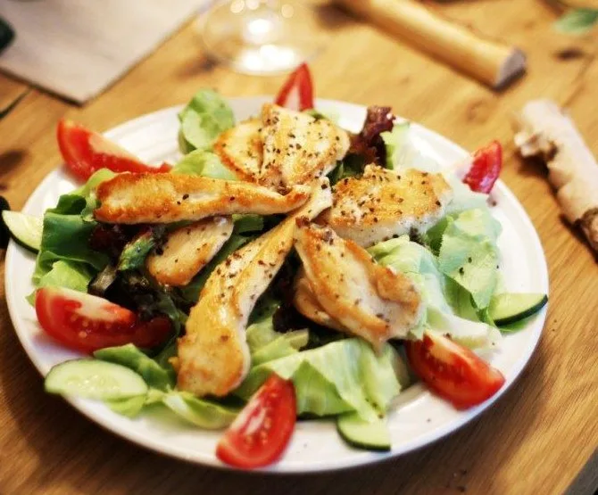 Gegrillte Hühnerfiletstreifen auf Blattsalat mit Tomaten