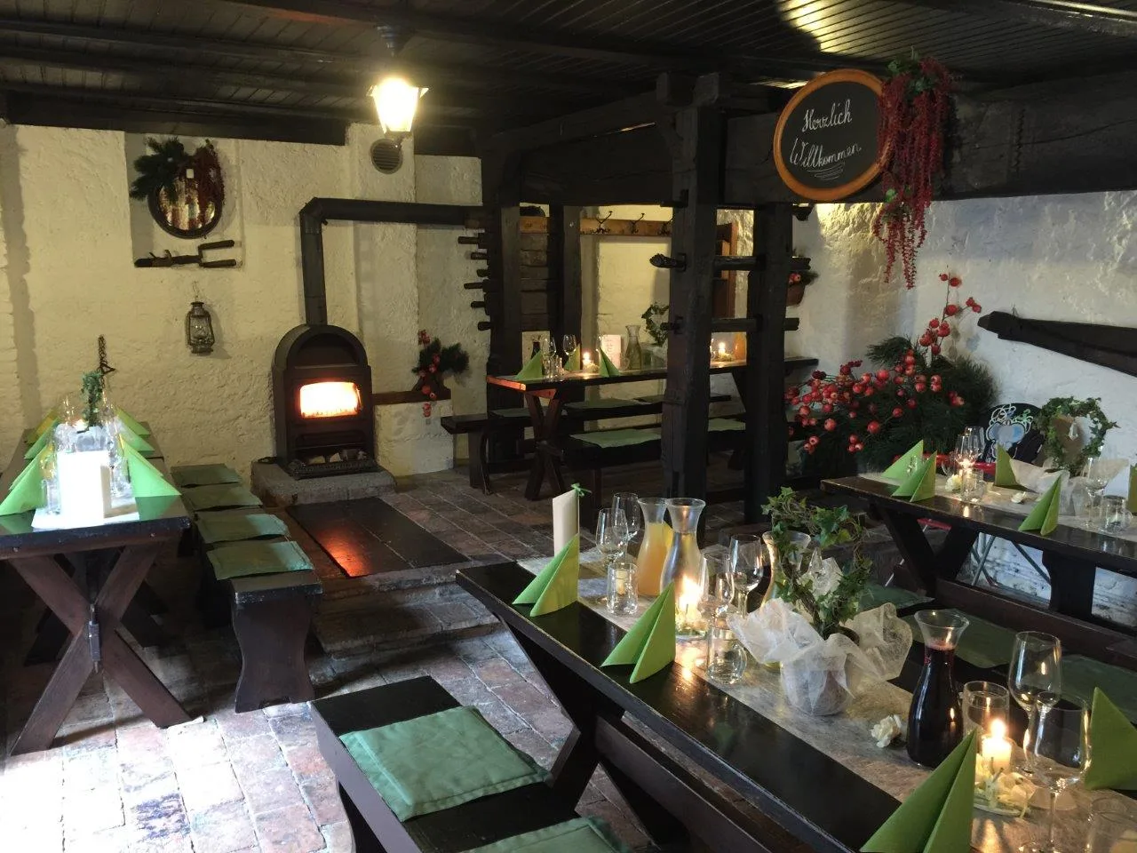 Gedeckte Tische in der Stube, im Hintergrund der gemauerte Ofen